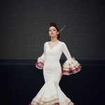 Vestido flamenca entallado en color crudo con mangas, volante grande con volantes pequeños en colores crudo, camel y granate. Con enagua amplia de rizo en organdí.