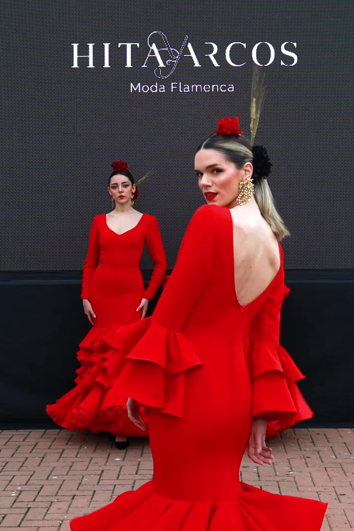 Vestido de flamenca rojo entallado en tejido elástico con manga en detalle copa plisada y un bordado en granate, volantes canasteros, la parte inferior del vestido esta compuesta por volantes unido en forma canastera  y con una gran enagua de rizo en organdí.