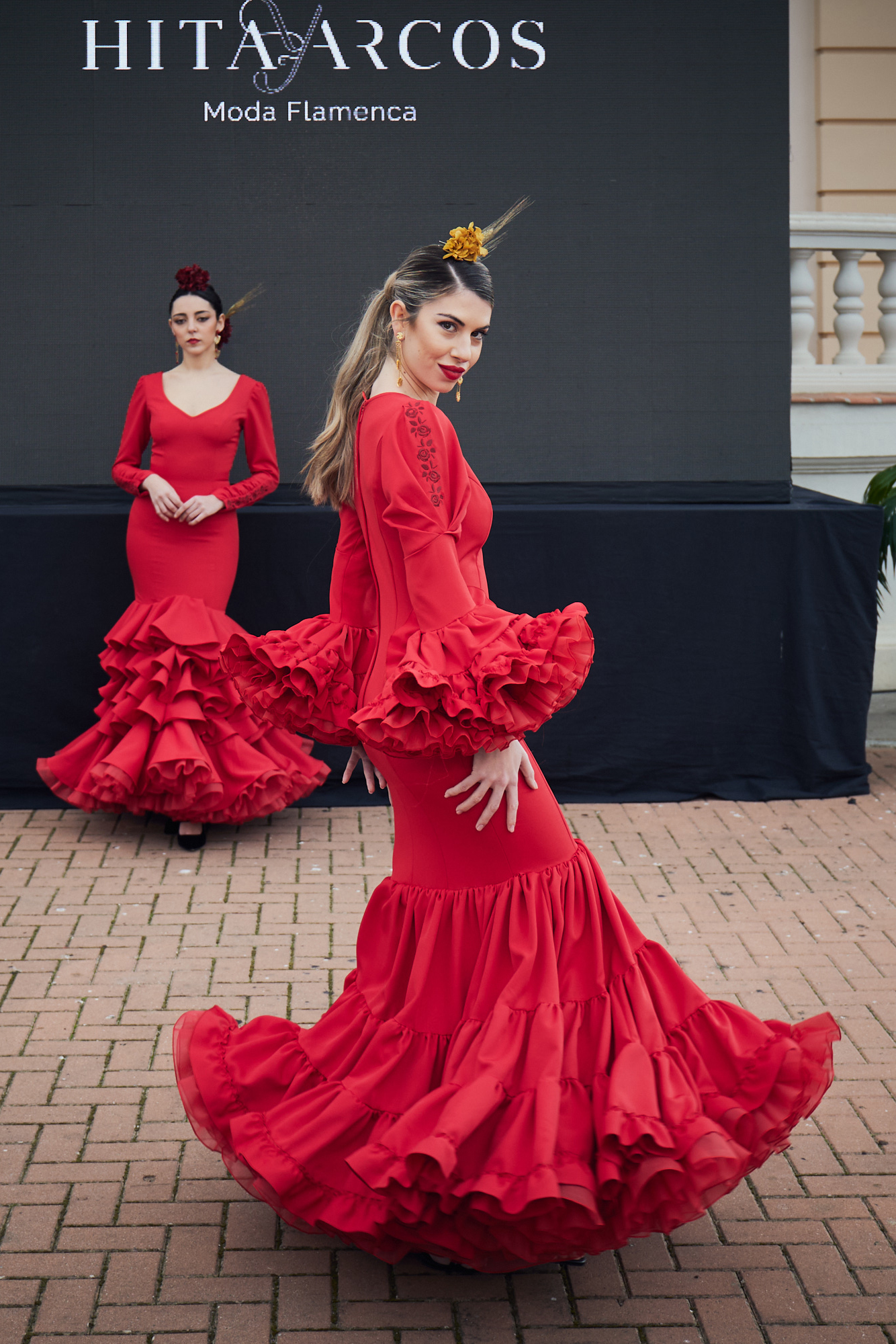 Vestido de flamenca rojo entallado en tejido elástico con manga en detalle copa plisada y un bordado en granate, la parte inferior del vestido esta compuesta por volantes unido en forma canastera  y con una gran enagua de rizo en organdí.