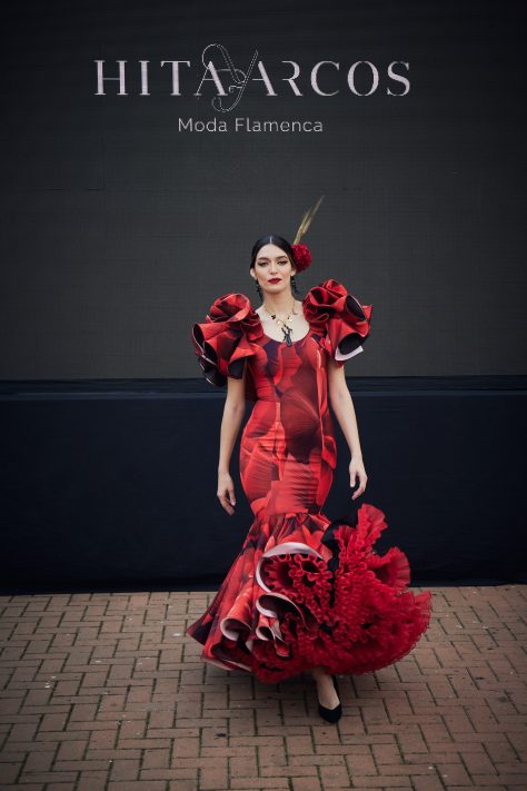 Vestido flamenca estampado rojo y negro, mangas con volante en pétalo, parte inferior volante asimétrico de mayor a menor y volante canastero en tejido liso negro, gran enagua de capa y rizo en rojo