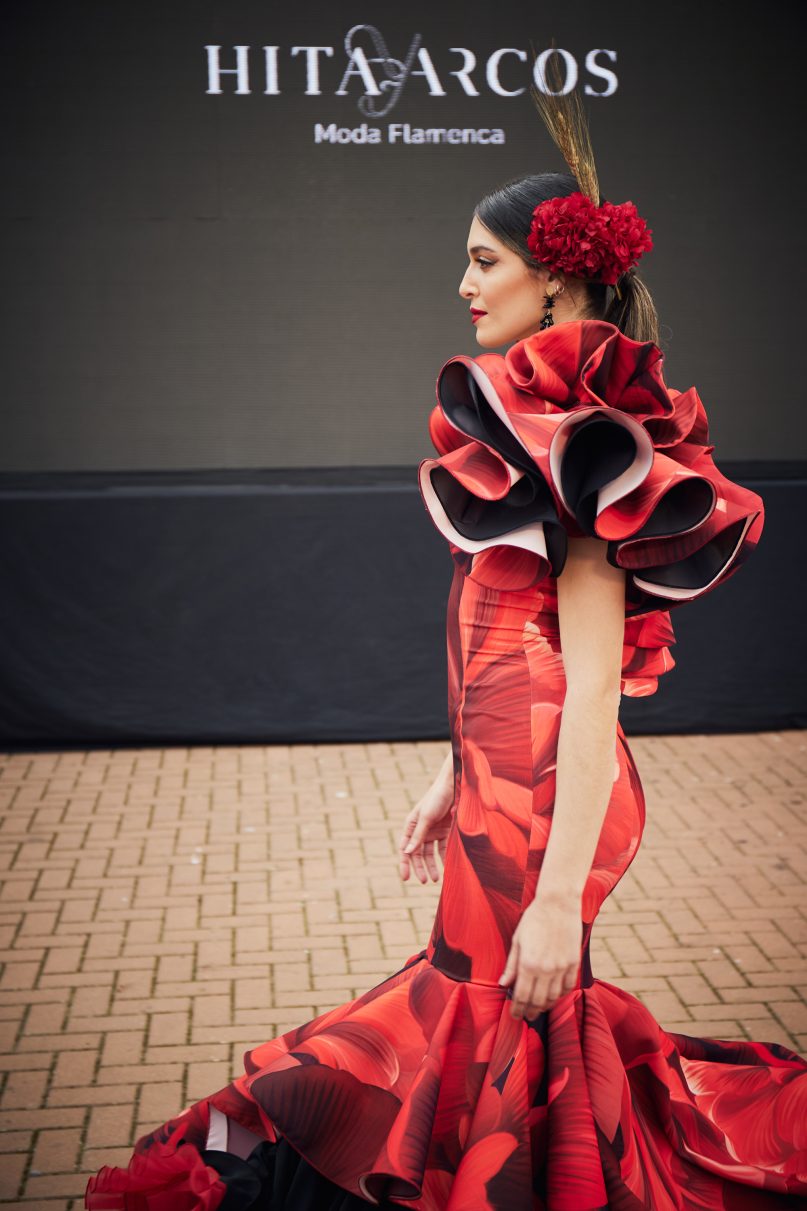 Vestido flamenca estampado rojo y negro, mangas con volante en pétalo, parte inferior volante asimétrico de mayor a menor y volante canastero en tejido liso negro, gran enagua de capa y rizo en rojo