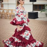 Vestido flamenca de nesgas blanco estampado, mangas con volantes y en la parte inferior volantes haciendo forma geométrica de rombo además de una gran volante con mucho volumen y rizos de organdí.