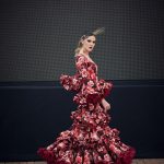 Vestido flamenca de nesgas estampado granate, mangas con volantes y en la parte inferior conjuntos de tres volantes pequeños ademans de una gran volante con mucho volumen y rizos de organdi.