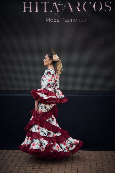 Vestido flamenca de nesgas blanco estampado, mangas con volantes y en la parte inferior volantes haciendo forma geométrica de rombo además de una gran volante con mucho volumen y rizos de organdí.