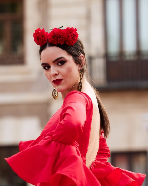 Vestido flamenca rojo con tres volantes dobles enganchado, escote delantero en lagrima con adorno de pasamanería, escote espalda amplio y mangas largas también con volante doble. Volantes con mucho volumen