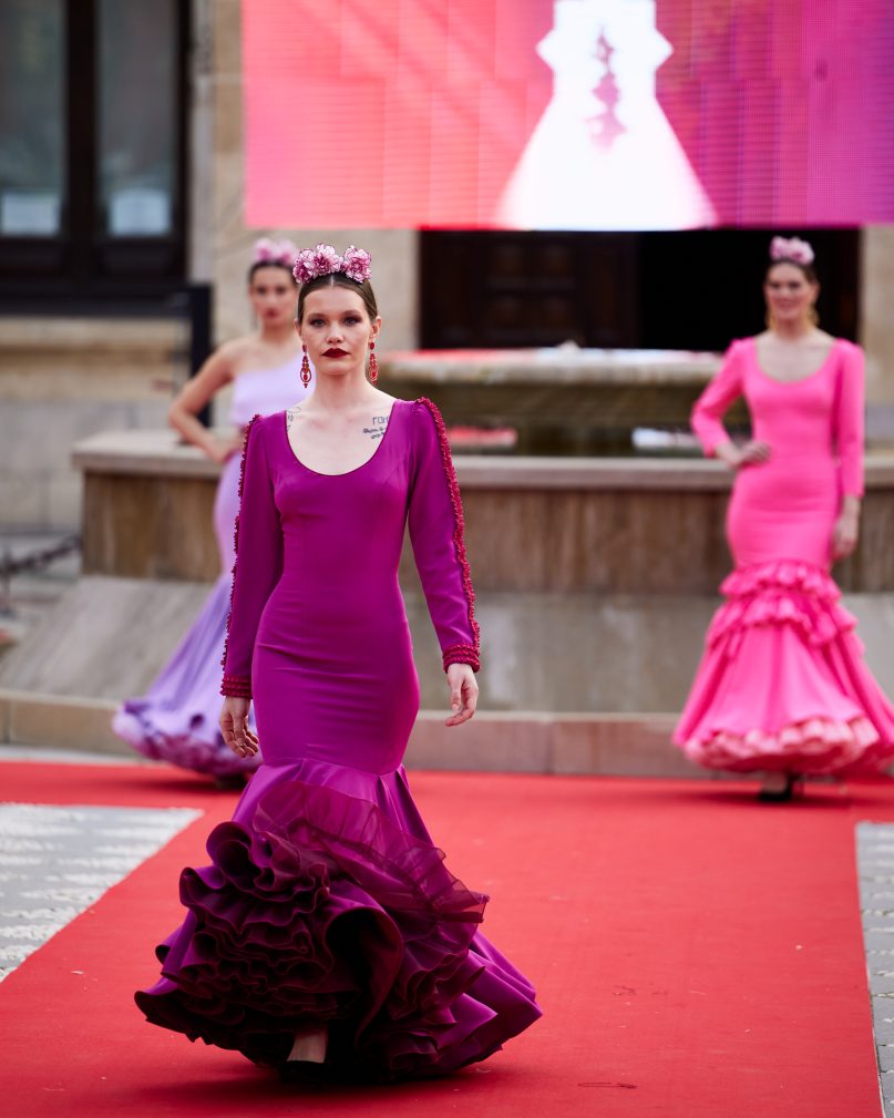 Vestido flamenca buganvilla en tejido elástico, manga lisa con adorno de pasamanería, escote delantero y trasero redondo amplios, volante grande enchanchado a otro volante con enagua de organdí