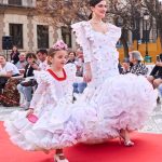 Vestido flamenca exclusivo algarabía en tejido de algodón bordado con hilo de colores, con manga larga, escote corazón delantero y cuadrado trasero, volante plisado en distintos tamaños como adorno sobre el cuerpo y volante grande en el inferior enagua clavel muy voluminoso blanco con el borde de colores