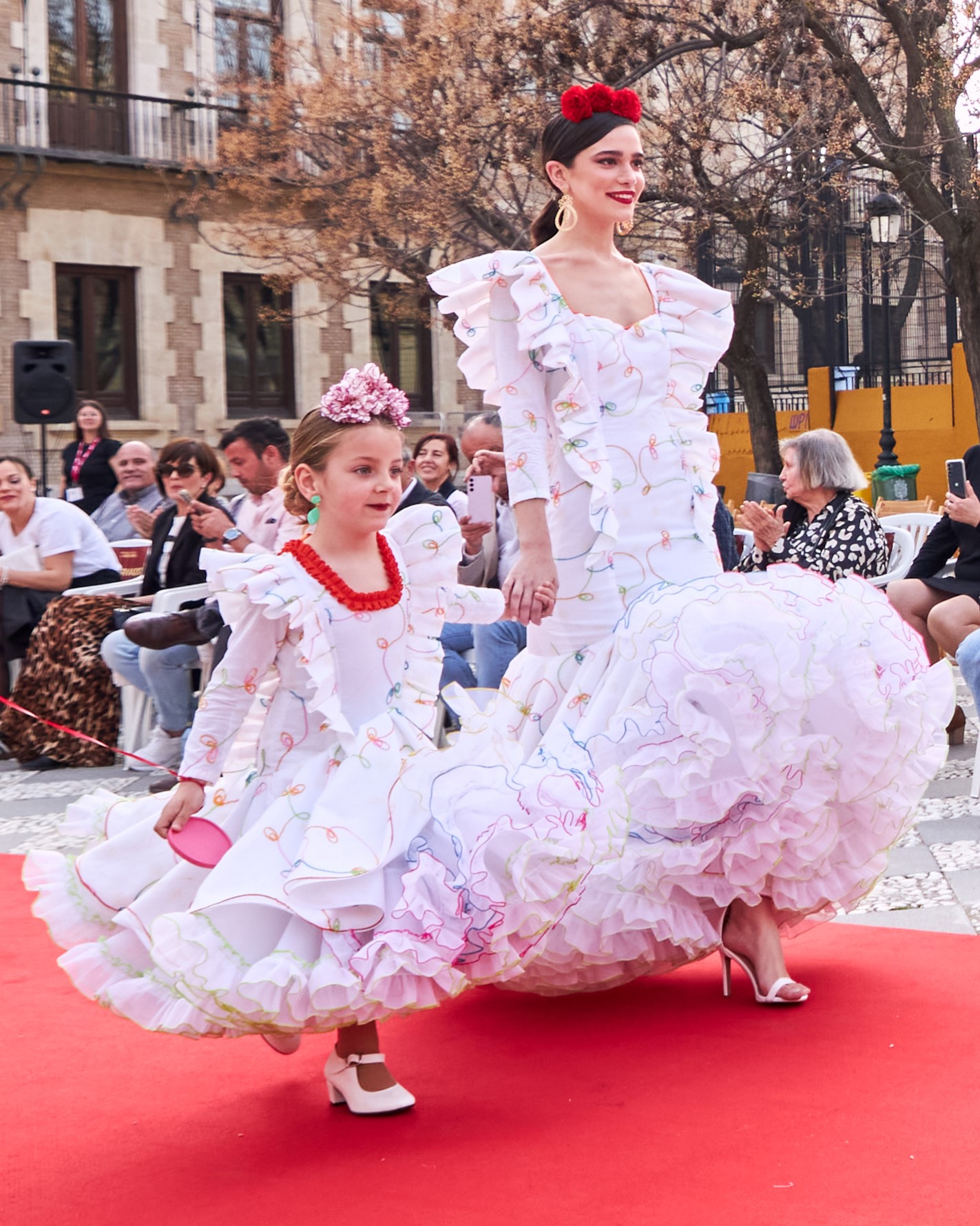 Vestido flamenca exclusivo algarabía en tejido de algodón bordado con hilo de colores, con manga larga, escote corazón delantero y cuadrado trasero, volante plisado en distintos tamaños como adorno sobre el cuerpo y volante grande en el inferior enagua clavel muy voluminoso blanco con el borde de colores