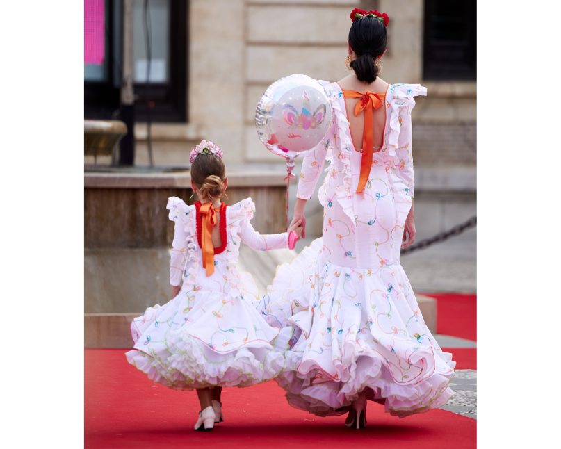 Vestido flamenca exclusivo algarabía en tejido de algodón bordado con hilo de colores, con manga larga, escote corazón delantero y cuadrado trasero, volante plisado en distintos tamaños como adorno sobre el cuerpo y volante grande en el inferior enagua clavel muy voluminoso blanco con el borde de colores