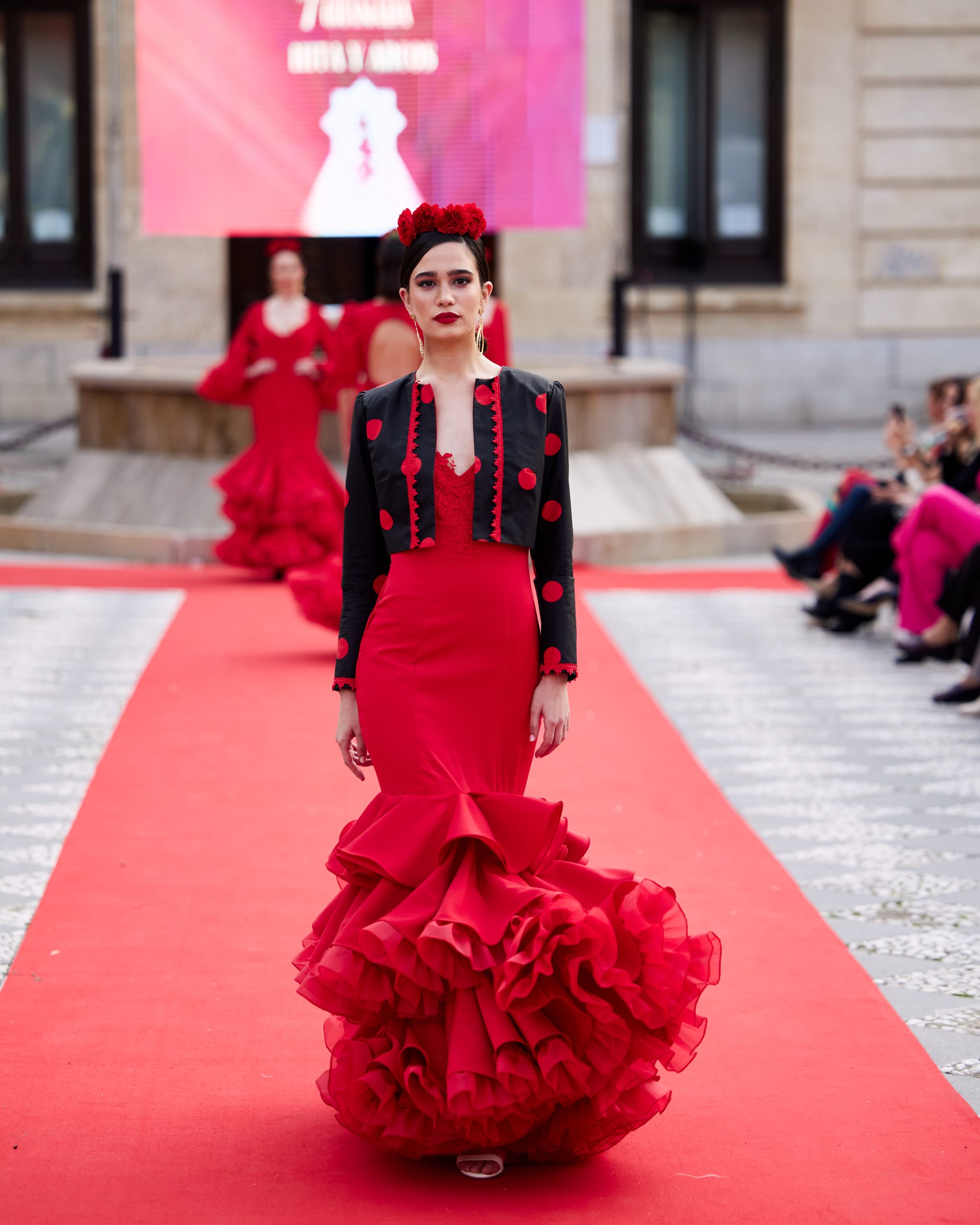 Vestido flamenca rojo elástico con tres volantes con rizo debajo, sin mangas con escote en v en el delantero y espalda con adorno de pasamanería