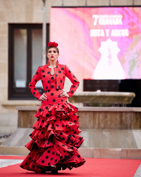 Vestido flamenca rojo con lunar negro con cinco volantes amplios encarados, sin mangas con escote en v muy pronunciado en el delantero y espalda