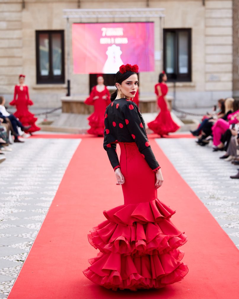 Vestido flamenca rojo elástico con tres volantes con rizo debajo, sin mangas con escote en v en el delantero y espalda con adorno de pasamanería