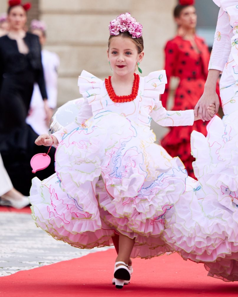 Vestido flamenca exclusivo algarabía en tejido de algodón bordado con hilo de colores, con manga larga, escote corazón delantero y cuadrado trasero, volante plisado en distintos tamaños como adorno sobre el cuerpo y volante grande en el inferior enagua clavel muy voluminoso blanco con el borde de colores